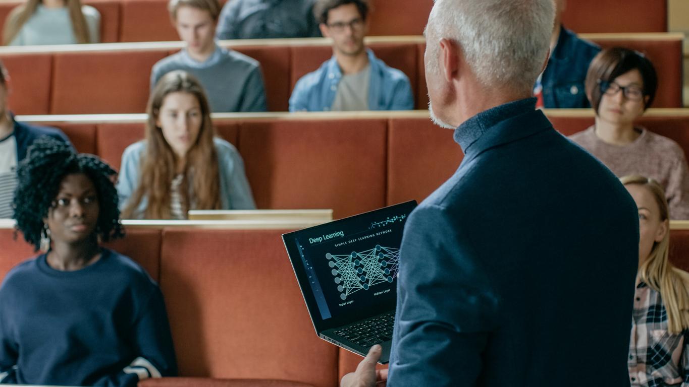 A lecturer speaks to a hall of students